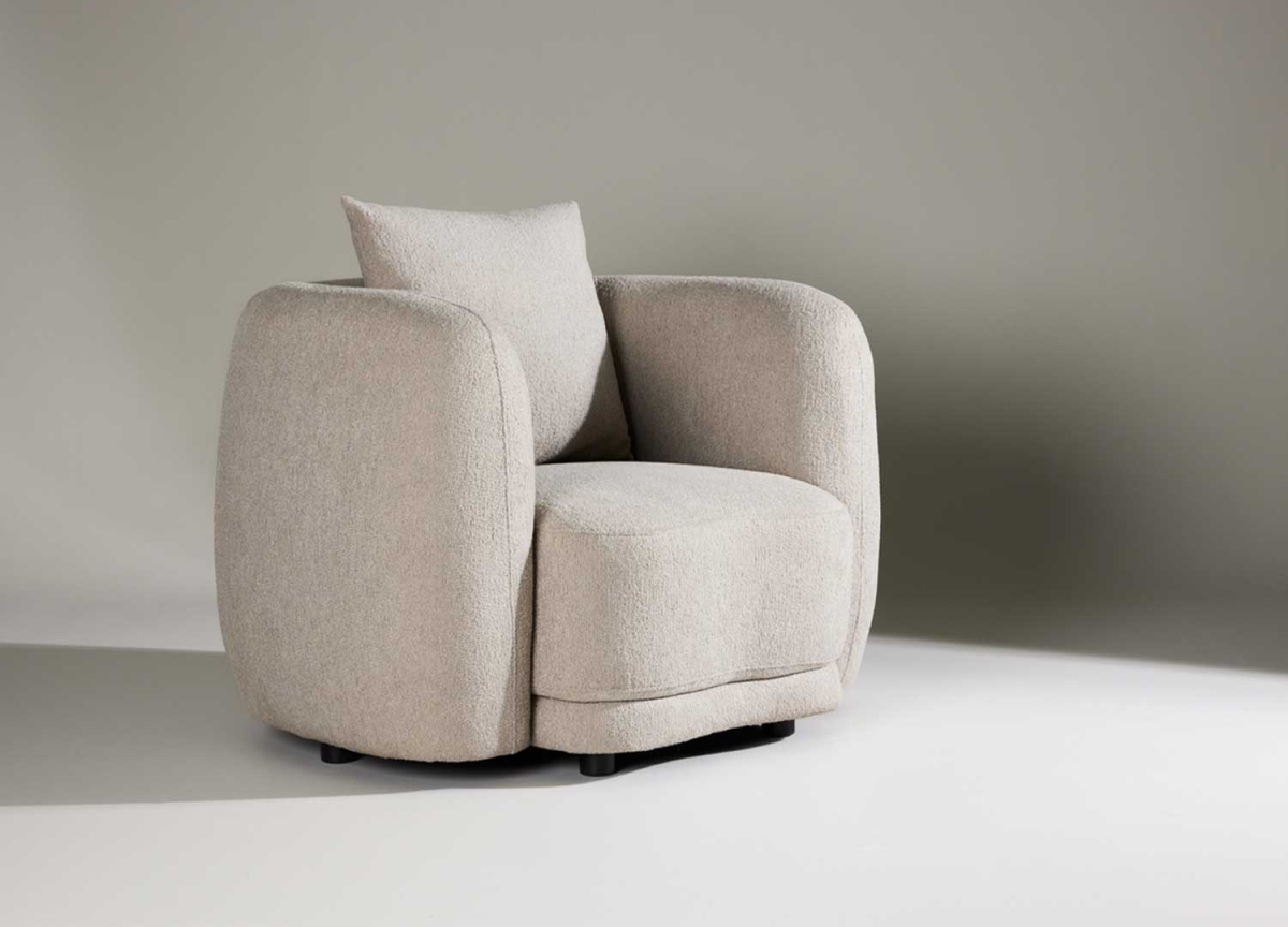 Fauteuil confortable en tissu bouclé beige avec accoudoirs et coussin